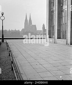 Blick von einem der Gebäude der Köln Messe zur Stadtseite mit dem Hohen Dom zu Köln und der Hohenzollernbrücke, Deutschland 1930er Jahre. Blick von einem der Kölner Messegebäude auf den Kölner Dom, Deutschland 1930er Jahre. Stockfoto