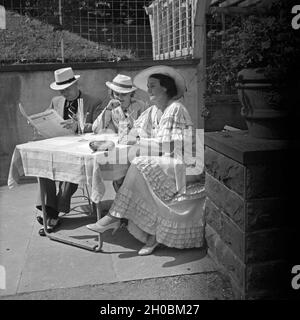 Ein Mann Sitzt Mit Zwei Frauen an Einem Tisch in Einem denkmalgeschützte Wildbad Im Schwarzwald, Deutschland, 1930er Jahre. Ein Mann und zwei Frauen sitzen in einem Gartenrestaurant im Wildbad im Schwarzwald, Deutschland der 1930er Jahre. Stockfoto