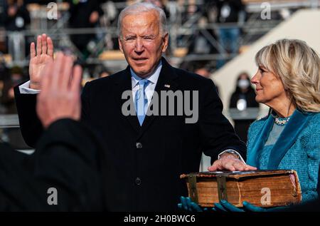 Der Präsident der Vereinigten Staaten Joseph R. Biden Jr. legt während der 59. Amtseinführung des Präsidenten im US-Kapitol, Washington, D.C. am 20. Januar 2021 den Amtseid ab. Während der Antrittszeit leistten Militärangehörige, die der Joint Task Force – National Capital Region zugewiesen wurden, militärische zeremonielle Unterstützung. Stockfoto