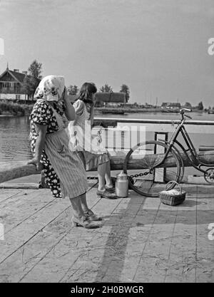 Eine Frau und ein Mädchen auf der Fähre über den induktionskopfhörern Nemonien im Memeldelta, Ostpreueßn, 1930er Jahre. Eine Frau und ein Mädchen auf der Fähre auf dem Fluss Memel Nemonien im Delta, Ostpreußen, 1930er Jahre. Stockfoto