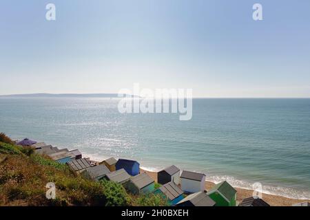 Strandhütten am Hordle Cliff Beach mit der Isle of Wight im Hintergrund Stockfoto