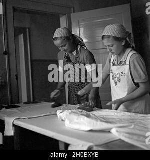 Zwei BdM Mädel beim Bügeln im Landjahr Lager in Polle an der Weser, Deutschland 1930er Jahre. Zwei BdM-Mädchen Bügeln der Wäsche im Camp in Polle, Deutschland 1930. Stockfoto