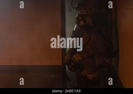 Ein Feuerwehrmann, der der 51. Zivilingenieursgeschwader zugewiesen wurde, beobachtet während einer Live-Feuerübung auf dem Osan Air Base, Südkorea, am 21. Januar 2021, einen Brand in einem veräußerten Wohnheim-Gebäude. Obwohl diese Schulung klein und in einem einzigen Raum untergebracht war, hofft die Feuerwehr, die Schulung auf die verschiedenen Stockwerke, mehrere Räume und simulierte Opfer auszuweiten, die die Feuerwehrleute in einer Einrichtung ausbilden, in der sie normalerweise keinen Zugang zu diesen Schulungsstufen hätten. Stockfoto