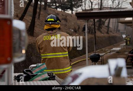 Ein Feuerwehrmann der US-Luftwaffe, der der 51. Zivilingenieursgeschwader zugewiesen wurde, steht am 21. Januar 2021 auf dem Luftwaffenstützpunkt Osan, Südkorea, unter Beobachtung. Die Feuerwehrleute haben die einzigartige Möglichkeit, in einem abgelegenen Wohnheim, das für den Abriss geplant ist, eingedämmt Brände zu entzünden. Stockfoto