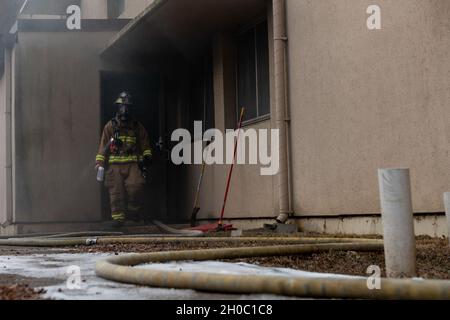 Am 21. Januar 2021 verlässt ein Feuerwehrmann, der der 51. Zivilingenieursgeschwader zugewiesen ist, eine Einrichtung, in der sie Live-Feuertrainings durchführen, auf dem Luftwaffenstützpunkt Osan, Südkorea. Das Gebäude ist eines von 20 Wohnheimen in Osan ab, die abgerissen oder renoviert werden, um die Lebensqualität in der gesamten Anlage zu erhöhen. Stockfoto