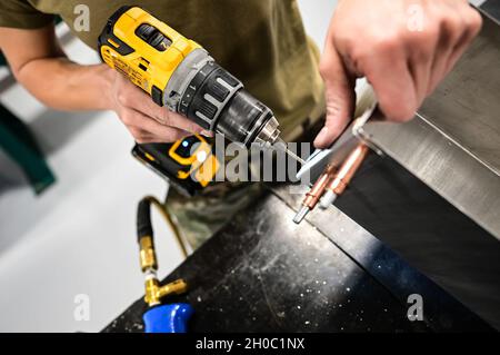 Technik. Sgt. Shelly Pavcik, 911th Maintenance Squadron Aircraft Structural Technician, bohrt ein Loch für eine Niete, um Metallteile zu befestigen, während er an der Pittsburgh International Airport Air Reserve Station, Pennsylvania, einen Versorgungskasten baute, 21. Januar 2021. Spezialisten für die strukturelle Instandhaltung fertigen Metallteile für verschiedene Flugzeug- und Fahrzeugreparaturen sowie Bauprojekte auf Basis. Stockfoto