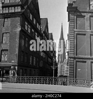 Blick durch eine Häuserflucht in die Nikolaikirche in Hamburg, Deutschland 1930er Jahre. Blick durch Bausteine in die St. Nikolai Kirche in Hamburg, Deutschland 1930. Stockfoto