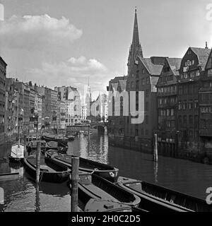 Eine Flotte in der Nähe der Nikolaikirche in Hamburg Speicherstadt, Deutschland 1930er Jahre. Einer der zahllosen Flottenkanäle in der Nähe der Nikolauskirche in der Hamburger Speicherstadt, Deutschland 1930er Jahre. Stockfoto