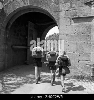 Drei Hitlerjungen kommen auf einer Wandertour durch Deutschland / Rothenburg o.d. Tauber, 1930er Jahre. Drei Hitler Jugend Wanderschaft durch Deutschland durch ein Tor von Rothenburg o.d. Tauber, 1930er Jahre. Stockfoto