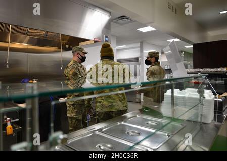 Von links: U.S. Air Force Tech. Sgt. Brian Vasvary, der Leiter der 354th Force Support Squadron Satellite Dining Facility (DFAC), und Senior Master Sgt. Abdullah Mustapha, der 354. FSS-Superintendent, führt den Kommandanten der 354. Mission Support Group, Oberst Stuart Williamson, auf der Eielson Air Force Base, Alaska, am 21. Januar 2021 durch das DFAC. Der DFAC mit Satellitenanschluss ist einer der beiden Speisemöglichkeiten, die an der Basis zur Verfügung stehen. Stockfoto