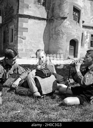 Drei Hitlerjungen rasten auf einer Wandertour in Rothenburg o.d. Tauber, 1930er Jahre. Drei Hitler Jugend in Rothenburg o.d. Tauber, 1930er Jahre ruhen. Stockfoto