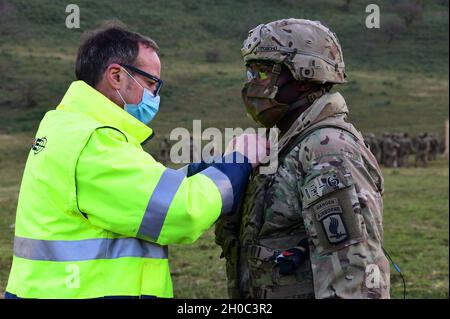 Links, Training Support Specialist Vincenzo Vitiello vom 7. ATC, TSC Livorno, stellte das Mikrofon für ein Interview mit Oberstleutnant der US-Armee, Kitefre K. Oboho, Kommandant 1. Bataillon, 503. Infanterie-Regiment, 173. Luftbrigade während der Übung Eagle Talon auf dem Monte Romano Trainingsgebiet, Italien, 20. Januar 2021, Stockfoto