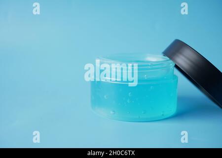 Ein Glas Haargel auf blauem Hintergrund mit Platz zum Kopieren Stockfoto