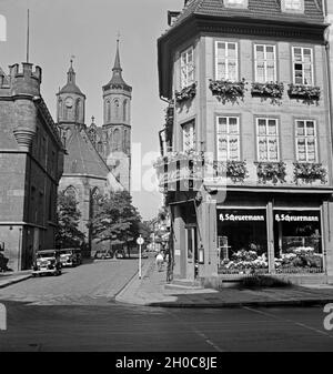 Blick auf die Johanniskirche in Göttingen, vorbei am Rathaus und bin Blumengeschäft Scheuermann, Deutschland 1930er Jahre. Anzeigen neben dem Rathaus und dem blumenladen Scheuermann zu te St. John's Church in Göttingen, Deutschland 1930. Stockfoto