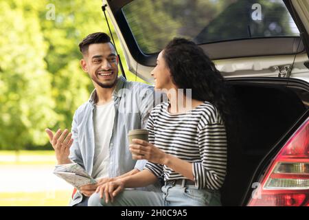 Glückliche Liebhaber, die mit dem Auto reisen und eine Kaffeepause machen Stockfoto