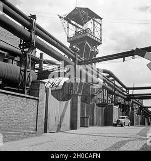 Förderturm der Krupp Gußstahlfabrik in Essen, Deutschland 30er Jahre. Kopfbedeckungen der Krupp Stahl arbeitet in Essen, Deutschland 1930. Stockfoto