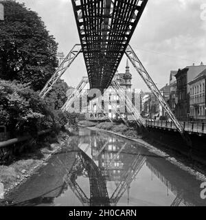 Die Strecke der Wuppertaler Schwebebahn spiegelt sich in der Wupper, Deutschland 1930er Jahre. Wuppertaler Schwebebahn refelcting in die Wupper, Deutschland 1930. Stockfoto