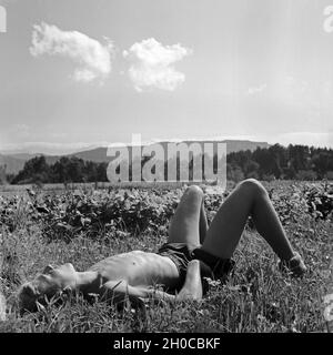 Erschöpfter Hitlerjunge Balatonfüred in einer Wiese, Österreich 1930er Jahre. Erschöpft Hitler Jugend Junge lag auf einem Rasen, ein Nickerchen, Österreich 1930. Stockfoto