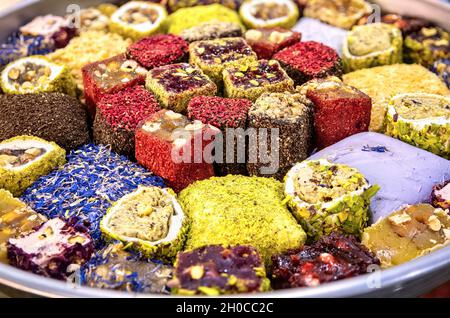 Orientalische Süßigkeiten. Verschiedene traditionelle türkische Delight (Rahat Lokum) auf Gericht. Türkische Freude mit verschiedenen Nüssen und Kokosnussspangen. Draufsicht Schließen- Stockfoto