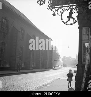 Schulkind vor einem Haus mit dem Rattenfänger in Hameln an der Weser, Deutschland 1930er Jahre. Schule Mädchen vor einem Haus mit Symbol der Rattenfänger in der Altstadt von Hameln auf der Weser, Deutschland 1930. Stockfoto