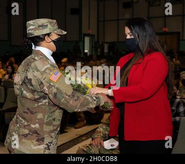 Kory Lopez, Ehefrau des neuen Senior-Berater, Command Sgt. Maj. Jaime Lopez erhält gelbe Rosen, um sie in der Familie der Spartan Brigade während eines Kampfteams der 2. Panzerbrigade, 3. Infanteriedivision, Zeremonie zur Änderung der Verantwortung, am 22. Januar 2021, im Woodruff Theater in Fort Stewart, Georgia, willkommen zu heißen. Stockfoto