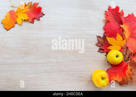 Herbstdekor aus Blättern und gelbem Apfel auf Holzgrund. Flach Lay Herbst Komposition mit Kopierraum. Stockfoto