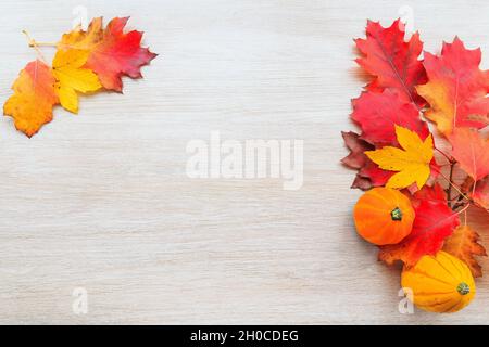 Herbstdekor aus Kürbissen und Blättern auf Holzhintergrund. Flach Lay Herbst Komposition mit Kopierraum. Stockfoto