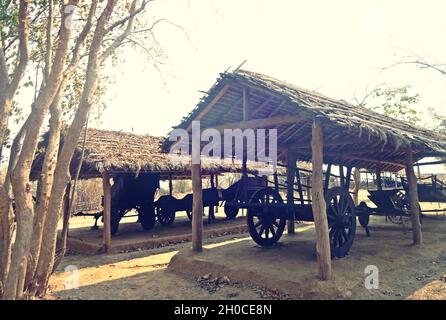 Ein alter Holzwagen, der unter dem Strohdach im ländlichen Raum geparkt wurde Stockfoto