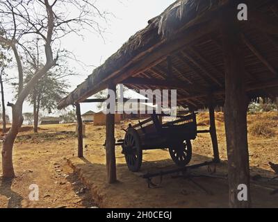 Ein alter Holzwagen, der unter dem Strohdach im ländlichen Raum geparkt wurde Stockfoto