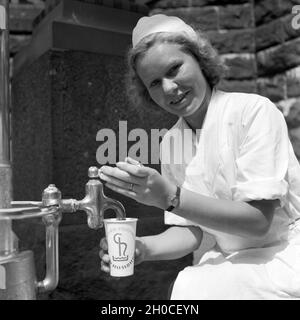 Eine Krankenschwester Im Kurbad Bad Homburg eine Einer Heilwasserquelle, 1930er Jahre Deutschland. Eine Krankenschwester auf einen Brunnen Heilwasser bei Kurort Bad Homburg, Deutschland der 1930er Jahre. Stockfoto