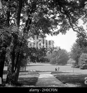 Ein Paar spaziert durch den Kurpark von Bad Homburg, Deutschland 1930er Jahre. Ein paar Flanieren durch die spa resort Gärten in Bad Homburg, Deutschland 1930. Stockfoto