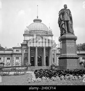 Blick in das Kaiser Wilhelms schlecht mit dem Denkmal für Kaiser Wilhelm I. in Bad Homburg, Deutschland 1930er Jahre. Blick auf die Kaiser-Wilhelms-Bad mit Kaiser Wilhelm I. Denkmal in Bad Homburg, Deutschland 1930. Stockfoto