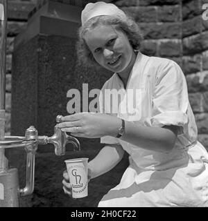 Eine Krankenschwester Im Kurbad Bad Homburg eine Einer Heilwasserquelle, 1930er Jahre Deutschland. Eine Krankenschwester auf einen Brunnen Heilwasser bei Kurort Bad Homburg, Deutschland der 1930er Jahre. Stockfoto