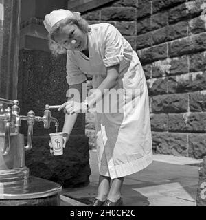 Eine Krankenschwester Im Kurbad Bad Homburg eine Einer Heilwasserquelle, 1930er Jahre Deutschland. Eine Krankenschwester auf einen Brunnen Heilwasser bei Kurort Bad Homburg, Deutschland der 1930er Jahre. Stockfoto