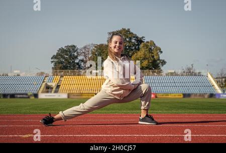 Läufer bereiten für den Wettbewerb Rennen. sprinter Aufwärmen auf Stadion-Turnhalle. Flexibilität. Kindertraining in der Schule Sportunterricht. Teenager-Mädchen Stockfoto