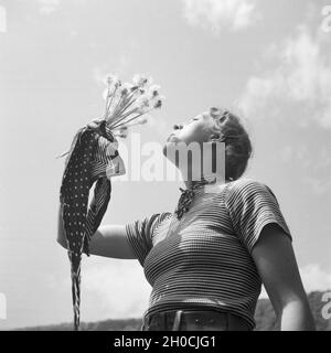 Eine Junge Frau Spielt Mit Löwenzahn, 1930er Jahre Deutschland. Eine junge Frau bläst die Samen des Löwenzahns, Deutschland der 1930er Jahre. Stockfoto