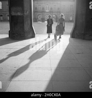 Zwei Junge Frauen Gehen in der Stadt Mit Dem Hund Spazieren, 1930er Jahre Deutschland. Zwei junge Frauen, Spaziergang mit dem Hund in der Stadt, Deutschland der 1930er Jahre. Stockfoto