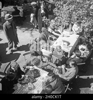 Menschen einer in Einem denkmalgeschützte, 1930er Jahre Deutschland. Leute sitzen in ein Gartenrestaurant, Deutschland der 1930er Jahre. Stockfoto