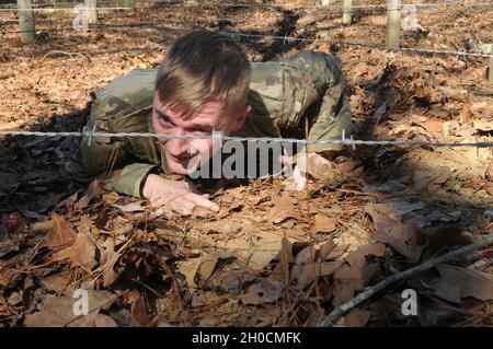 SPC der US-Armee. Joshua Fox, ein Ingenieur bei der 441st Transportation Company mit Sitz in New Orleans, klettert unter einem Hindernis am 23. Januar 2021 war Ala. Fox als Teil des 642. Wettbewerbs der Regional Support Group Best Warrior in Fort McClellan der zweite Platz für den am besten eingetragenen Soldaten im Wettbewerb. Stockfoto