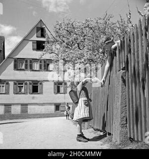 Eine Frau Verschenkt Süßigkeiten eine Ein Schulkind, 1930er Jahre Deutschland. Eine Frau, ein Schulkind, Deutschland der 1930er Jahre Süßigkeiten geben. Stockfoto