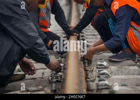 (211012) -- KUNMING/VIENTIANE, 12. Oktober 2021 (Xinhua) -- chinesische und laotische Mitarbeiter der China Railway No. 2 Engineering Group (CREC-2) Schrauben die Schiene nach dem Schweißen im nördlichen Vorort Vientiane, Laos, am 18. Juni 2020. (Foto von Kaikeo Saiyasane/Xinhua) Stockfoto