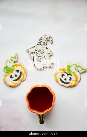 Halloween Kreativkonzept: Kürbisbecher und hausgemachte Kekse in Form von niedlichen Kürbissen und GeisterNahaufnahme. Ästhetische Herbststimmung oder Trick or Treat Konz Stockfoto