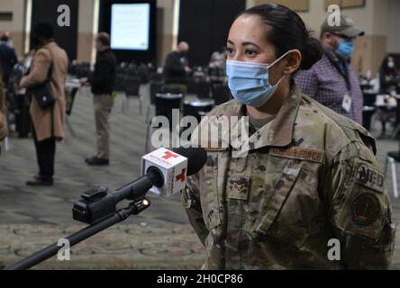 Der leitende Airman Katia Campos aus Chicago, ein Mediziner des 182. Luftlift-Flügels, interviewt Telemundo Chicago am 25. Januar auf dem Gelände der Massenimmunisierung im Cook County im Tinley Park Convention Center in Tinley Park, Illinois. Campos ist einer der medizinischen Fachkräfte der Illinois National Guard, die den Einwohnern des Bezirks vor Ort den Impfstoff COVID-19 verabreichen. Gouverneur JB Pritzker hat etwa 400 Mitglieder der Illinois National Guard aktiviert, um Gesundheitsbehörden im Bundesstaat bei der Impfung von Bewohnern von Illinois zu helfen. Stockfoto