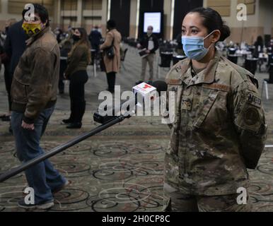 Der leitende Airman Katia Campos aus Chicago, ein Mediziner des 182. Luftlift-Flügels, interviewt Telemundo Chicago am 25. Januar auf dem Gelände der Massenimmunisierung im Cook County im Tinley Park Convention Center in Tinley Park, Illinois. Campos ist einer der medizinischen Fachkräfte der Illinois National Guard, die den Einwohnern des Bezirks vor Ort den Impfstoff COVID-19 verabreichen. Gouverneur JB Pritzker hat etwa 400 Mitglieder der Illinois National Guard aktiviert, um Gesundheitsbehörden im Bundesstaat bei der Impfung von Bewohnern von Illinois zu helfen. Stockfoto