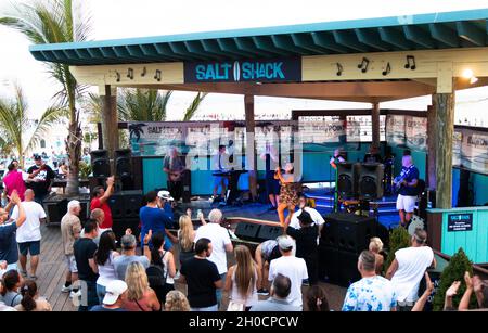 Babylon, New York, USA - 20. August 2021: Band spielt auf der Bühne im Salt Shack draußen am Cedat Beach mit Menschen, die davor stehen und tanzen. Stockfoto