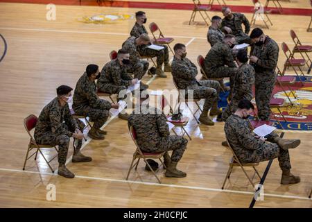 Dienstmitglieder mit 1. Bataillon, 6. Marine-Regiment, 2. Marine-Division warten darauf, aus dem Göttge Memorial Field House ausgecheckt zu werden, nachdem sie den COVID-19-Impfstoff auf dem Marine Corps Base Camp Lejeune, North Carolina, am 25. Januar 2021 erhalten haben. Um einen maximalen Durchsatz von Mitarbeitern der II Marine Expeditionary Force zu ermöglichen, wurde das Feldhaus von der Basis vorübergehend umkonfiguriert, um als COVID-19-Impfzentrum ausschließlich für sie zu dienen. Stockfoto