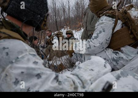 SPC. Christian Jensen, mit 1. Bataillon, 182. Field Artillery Regiment Delta Battery spricht mit seinem Team während eines engen Luftunterstützungs-Integrationstrainings für die Übung Northern Strike, während er in Camp Grayling, Grayling, Michigan, am 26. Januar 2021 war. Die Fähigkeit von ANGLICO, sich mit gemeinsamen, alliierten und Koalitionskräften in den Kampf um die Informationsumgebung zu integrieren, verbessert die Fähigkeit des Kommandanten, in einem komplexen und stark umkämpften Umfeld zu manövrieren. Stockfoto