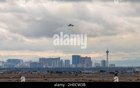 Ein F-15E Strike Eagle vom 336. Jagdgeschwader, Seymour Johnson Air Force Base, South Carolina, fährt über die Skyline des Las Vegas Strip für eine Mission mit der Roten Flagge 21-1 vom Nellis Air Force Base, Nevada, 26. Januar 2021. Der F-15 Strike Eagle ist ein Kämpfer mit zwei Rollen, der für die Durchführung von Luft-zu-Luft- und Luft-zu-Boden-Missionen entwickelt wurde. Stockfoto