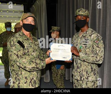 DIEGO GARCIA, Britisches Territorium im Indischen Ozean (Jan 27, 2021) – Fluglotse 1. Klasse Alexander B. Allen, der führende Kleinoffizier, der dem Air Operations Department der U.S. Navy Support Facility Diego Garcia zugewiesen wurde, erhält die Auszeichnung der Marine und des Marine Corps von Capt. R. Wade Blizzard, dem Kommandanten von NSF Diego Garcia, 27. Januar, 2021. NSF Diego Garcia bietet Logistik-, Service-, Freizeit- und administrative Unterstützung für US- und alliierte Truppen, die im Indischen Ozean und im Arabischen Golf eingesetzt werden. Stockfoto