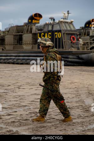 Eine US-Marine mit 2. Landing Support Bataillon beobachtet Landing Craft Air Cushion 70, Savage, während des Typ Commander's Amphibious Training im Camp Lejeune, N.C., 27. Januar 2021. Seeleute der US-Marine, die LCAC 70 zugewiesen wurden, lehrten Marineinfanteristen mit CLR2, wie sie mittlere taktische Fahrzeugumstellungen auf und aus dem Schiff ordnungsgemäß laden und entladen können. Stockfoto